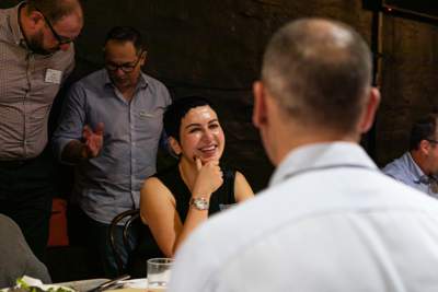 A room full of people mingling before the meal is served.