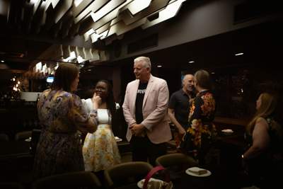 A room full of people mingling before the meal is served.