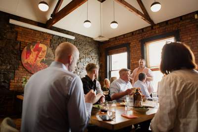 A room full of people mingling before the meal is served.