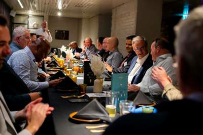 A room full of people mingling before the meal is served.